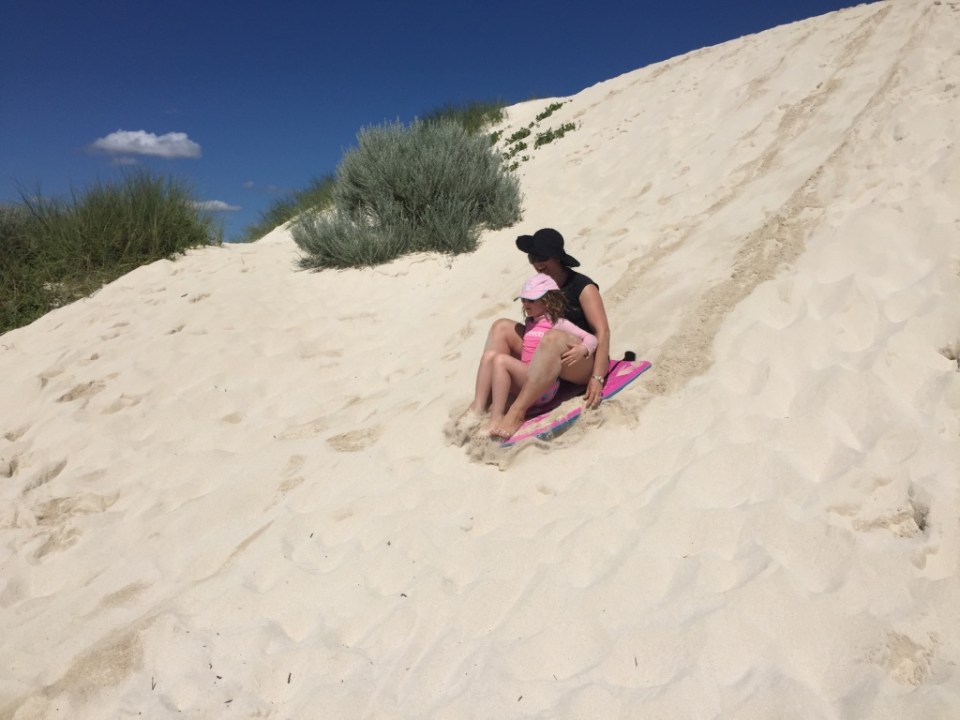 Holly rides the dune with Mum
