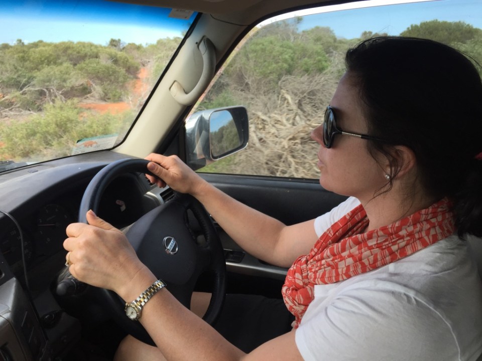 Michaela behind the wheel on the sandy tracks.