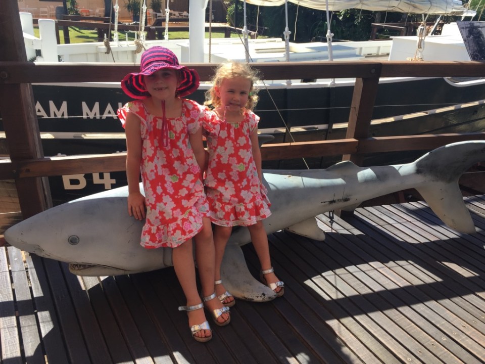 Girls next to a shark and pearl lugger boat
